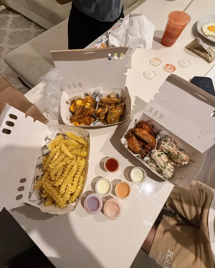 Pedido de alitas en varias salsas con papas y cremas